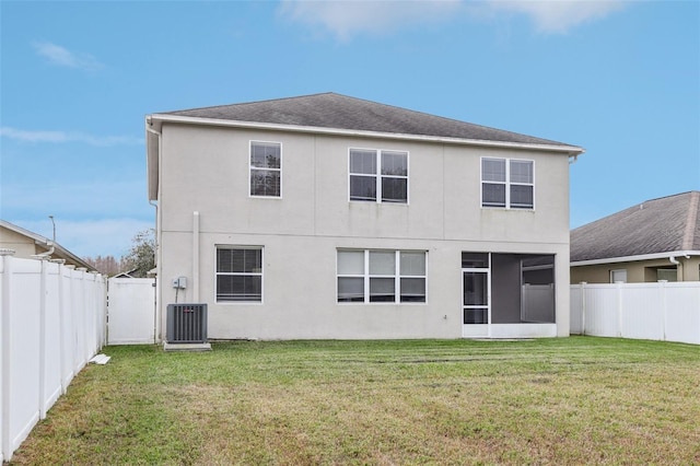 rear view of house with a yard and central AC