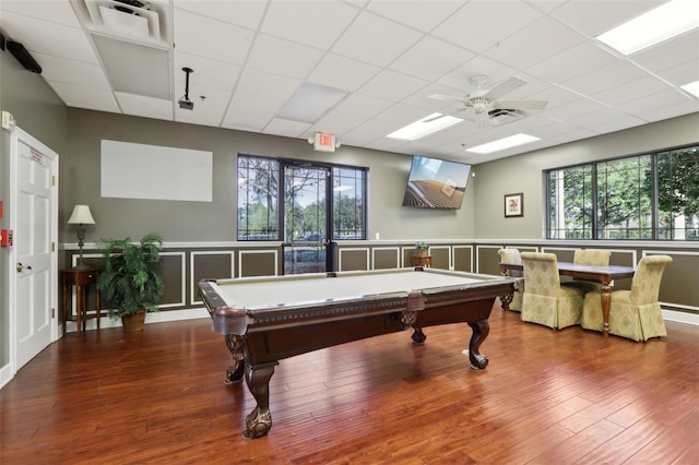 game room with a drop ceiling, hardwood / wood-style floors, and ceiling fan