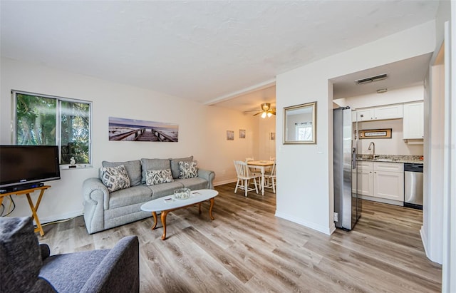 living room featuring sink and light hardwood / wood-style floors