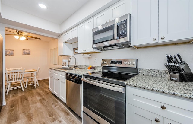 kitchen featuring sink, light hardwood / wood-style floors, white cabinets, and appliances with stainless steel finishes