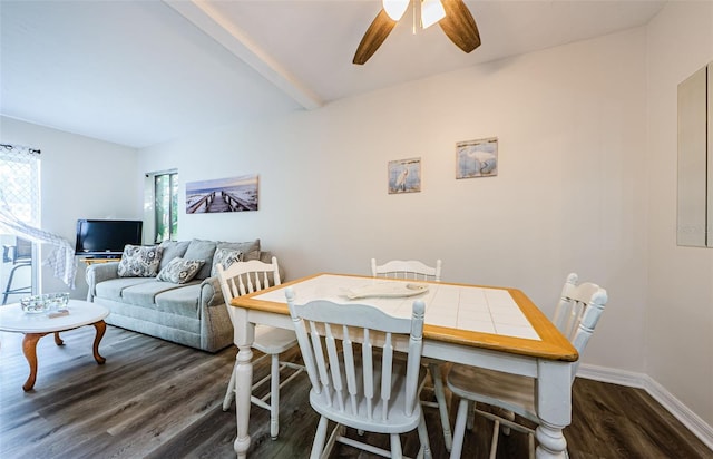 dining area featuring beamed ceiling, dark hardwood / wood-style floors, and ceiling fan