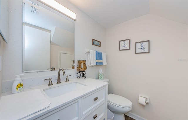 bathroom with vanity, lofted ceiling, and toilet