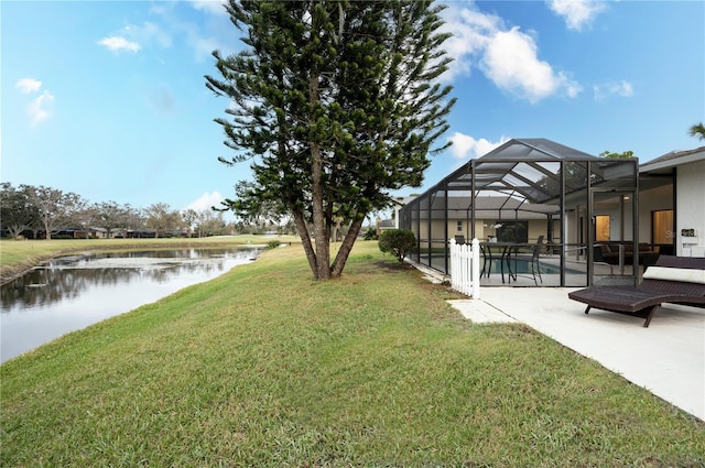 view of yard with a water view, glass enclosure, and a patio area