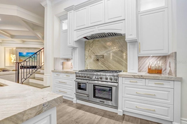 kitchen featuring coffered ceiling, backsplash, white cabinets, and range with two ovens