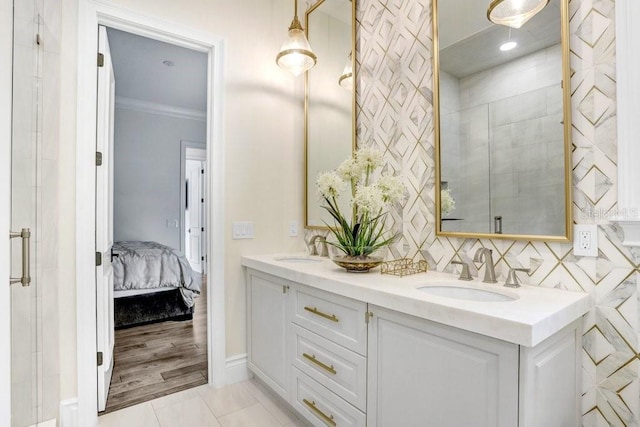 bathroom featuring vanity, tile patterned flooring, crown molding, and a shower with door