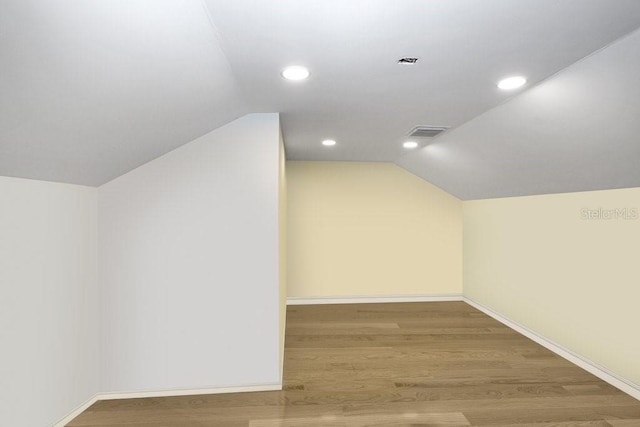 additional living space featuring vaulted ceiling and wood-type flooring