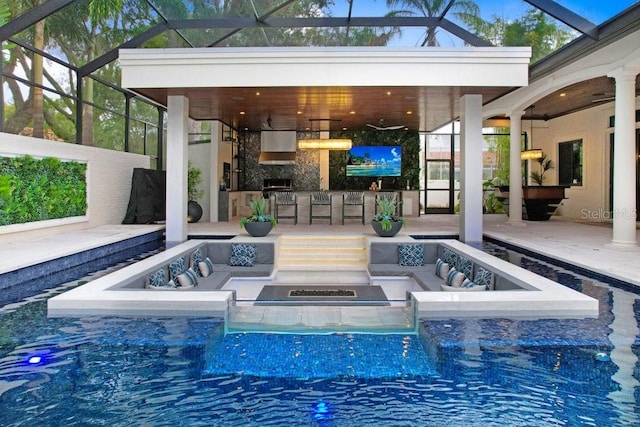 view of swimming pool featuring a patio, outdoor lounge area, an outdoor bar, and a lanai