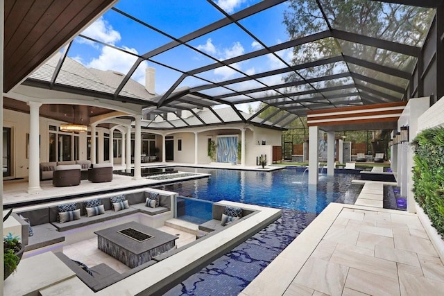 view of pool with ceiling fan, a patio, glass enclosure, and an outdoor living space with a fire pit