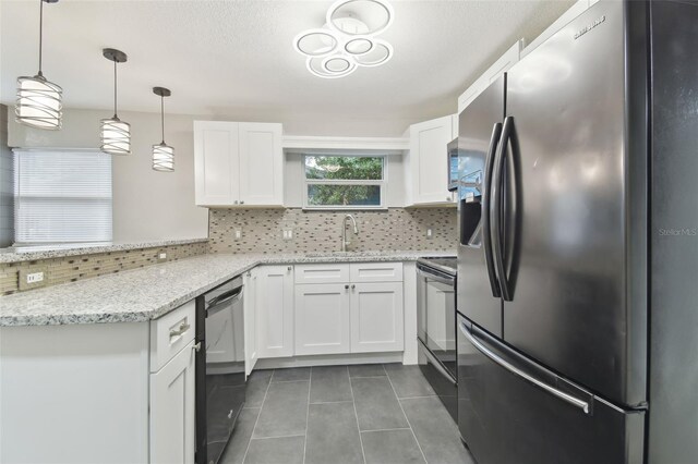 kitchen featuring a peninsula, a sink, stainless steel appliances, white cabinets, and tasteful backsplash