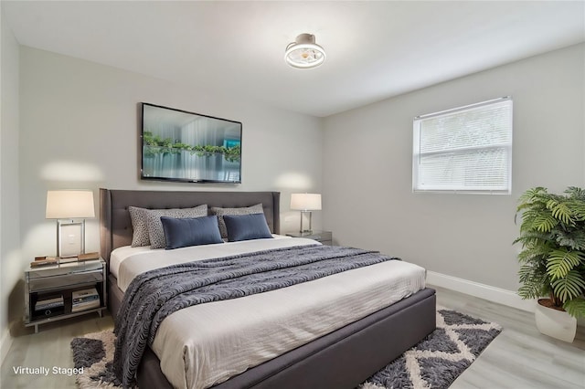 bedroom featuring baseboards and wood finished floors