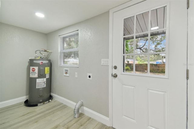 clothes washing area with electric water heater, baseboards, laundry area, wood finished floors, and electric dryer hookup