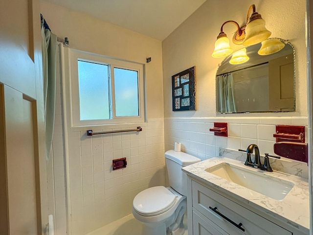 bathroom with tile walls, vanity, and toilet