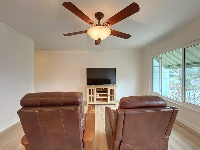 living room featuring crown molding, ceiling fan, and light hardwood / wood-style flooring