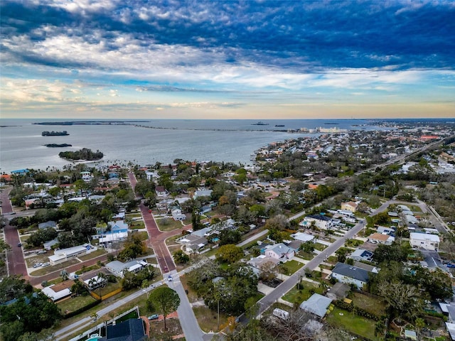 aerial view at dusk featuring a water view