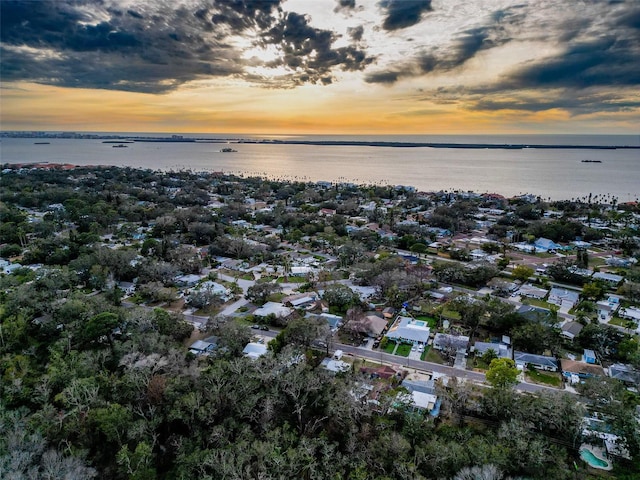 aerial view at dusk featuring a water view