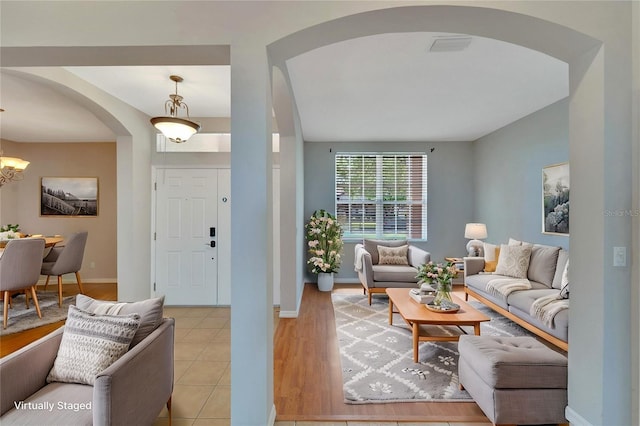 living room featuring an inviting chandelier and light tile patterned flooring