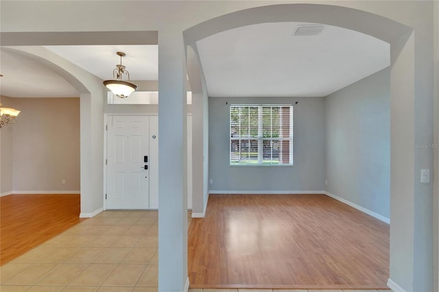 tiled foyer entrance featuring an inviting chandelier