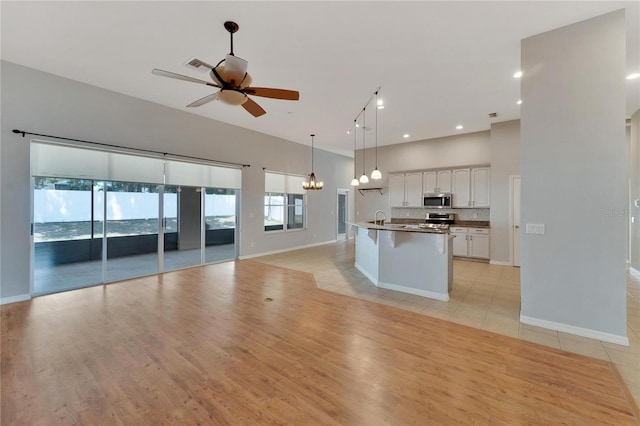 kitchen featuring white cabinetry, hanging light fixtures, plenty of natural light, and appliances with stainless steel finishes