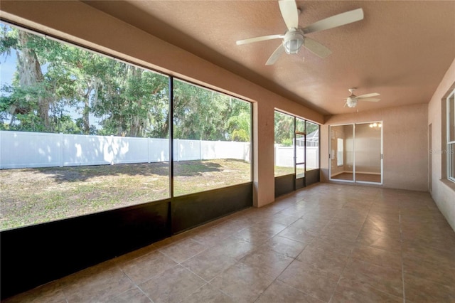 unfurnished sunroom with ceiling fan