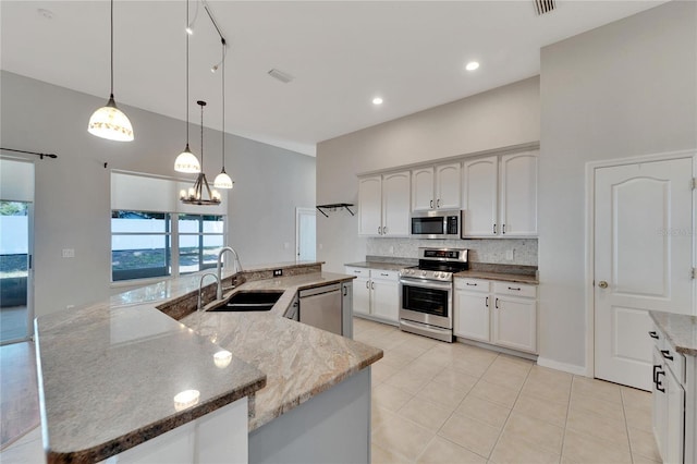 kitchen with pendant lighting, sink, a large island, white cabinetry, and stainless steel appliances