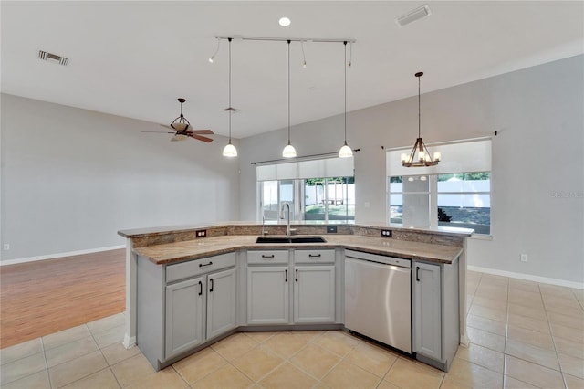 kitchen with sink, light tile patterned floors, an island with sink, decorative light fixtures, and stainless steel dishwasher