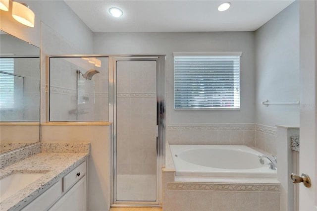 bathroom with vanity and shower with separate bathtub