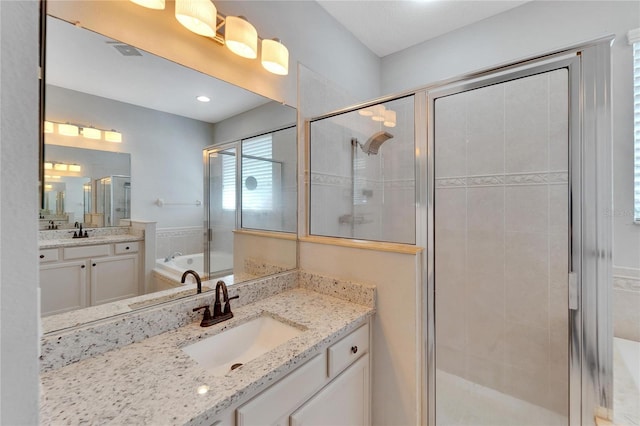 bathroom featuring vanity and shower with separate bathtub