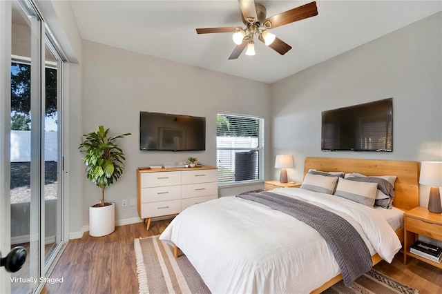 bedroom featuring access to exterior, dark hardwood / wood-style floors, and ceiling fan