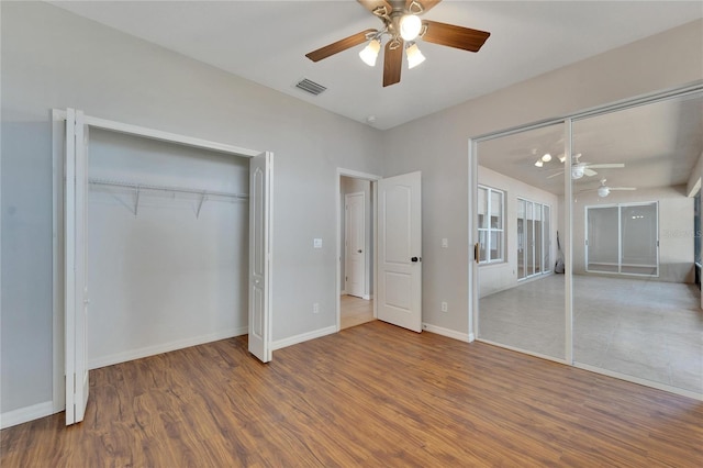 unfurnished bedroom with ceiling fan, wood-type flooring, and a closet