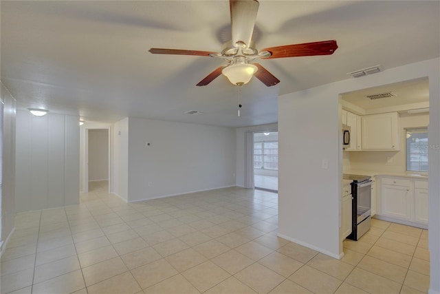 interior space featuring stainless steel appliances, white cabinetry, plenty of natural light, and light tile patterned floors