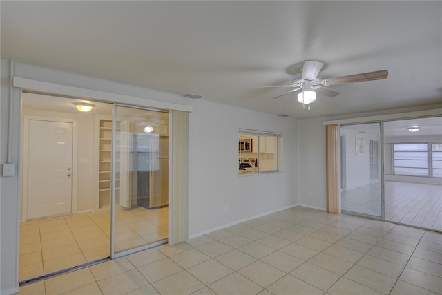 spare room with light tile patterned floors and ceiling fan