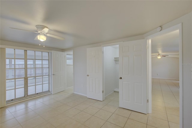 unfurnished room with light tile patterned floors and ceiling fan