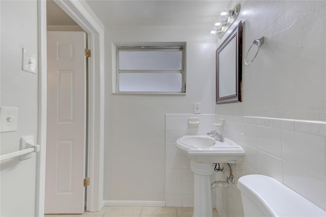 bathroom featuring tile walls, tile patterned flooring, and toilet