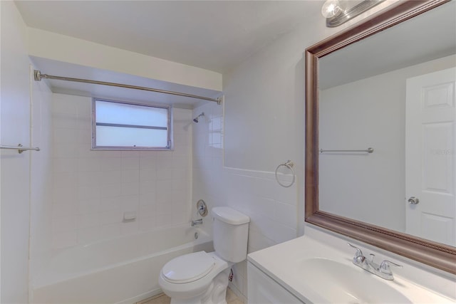 full bathroom featuring tiled shower / bath combo, vanity, tile walls, and toilet