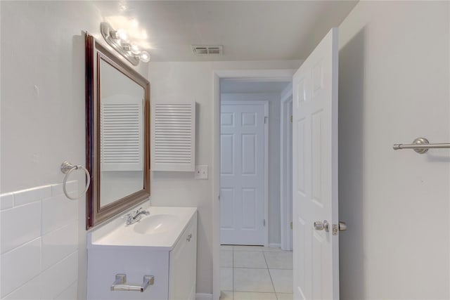 bathroom with vanity, tile patterned flooring, and tile walls