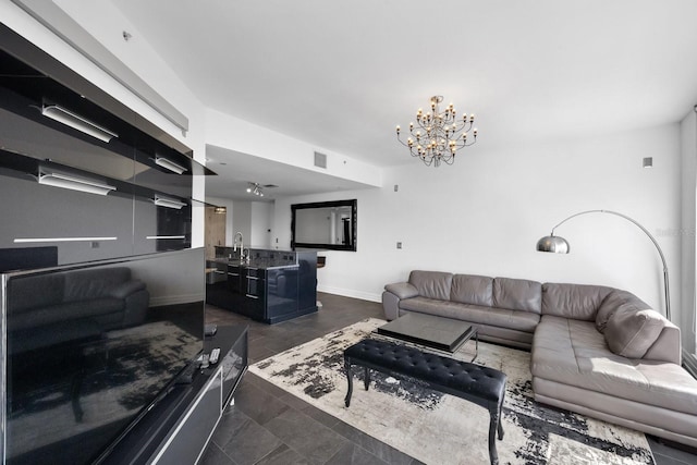 living room featuring a chandelier and baseboards