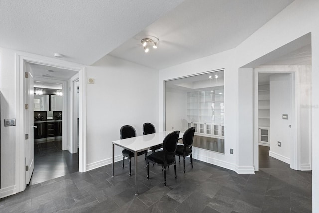 dining area with a textured ceiling and baseboards