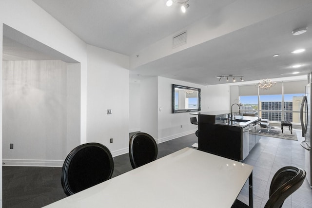 dining area with baseboards, visible vents, and a notable chandelier