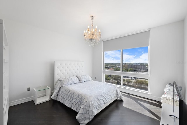 bedroom featuring dark wood-style floors, baseboards, and an inviting chandelier