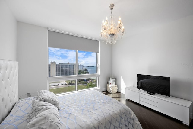 bedroom with dark wood-style flooring, a notable chandelier, and baseboards