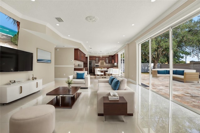 living room featuring light tile patterned flooring, ornamental molding, and a textured ceiling