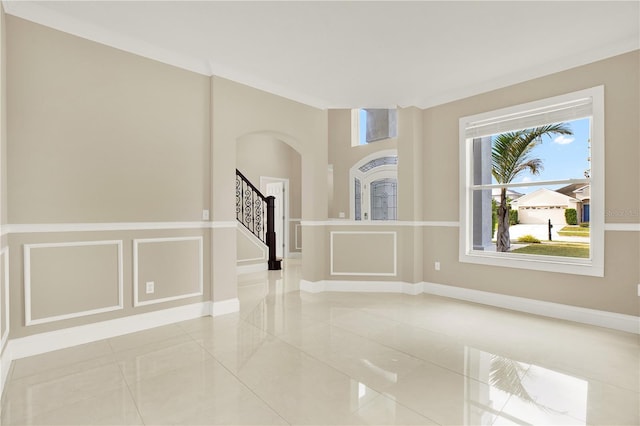 empty room with crown molding and light tile patterned flooring