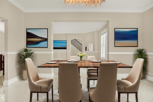 tiled dining space featuring crown molding and a chandelier