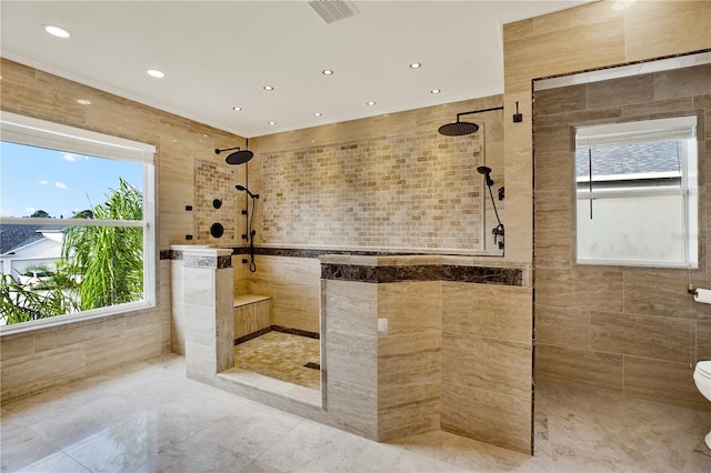 bathroom featuring tiled shower, toilet, and tile walls