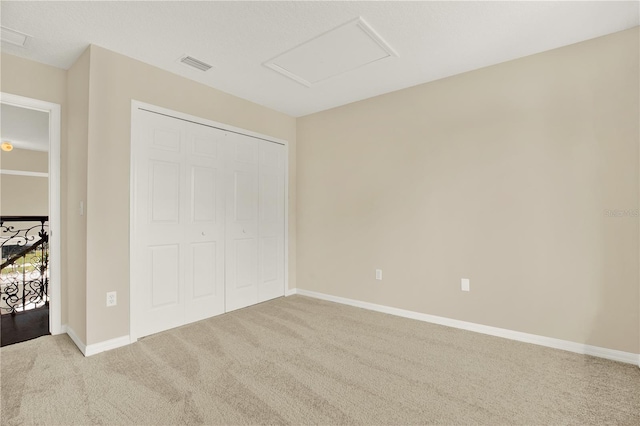 unfurnished bedroom featuring light carpet and a closet