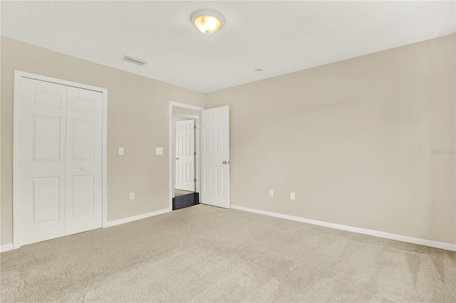 unfurnished bedroom featuring carpet and a closet