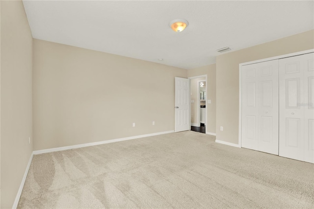 unfurnished bedroom with light carpet and a closet