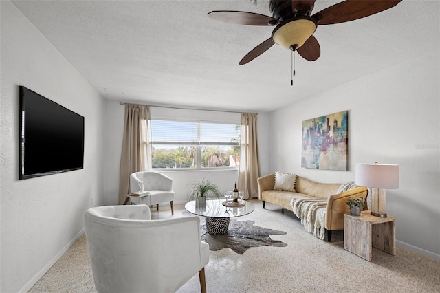 living room featuring a textured ceiling and ceiling fan