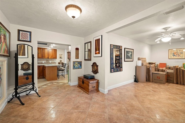 corridor featuring light tile patterned floors and a textured ceiling