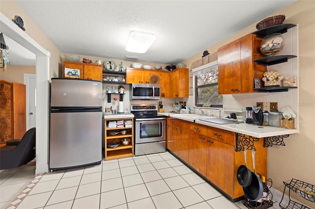 kitchen featuring sink, a textured ceiling, light tile patterned floors, appliances with stainless steel finishes, and decorative backsplash